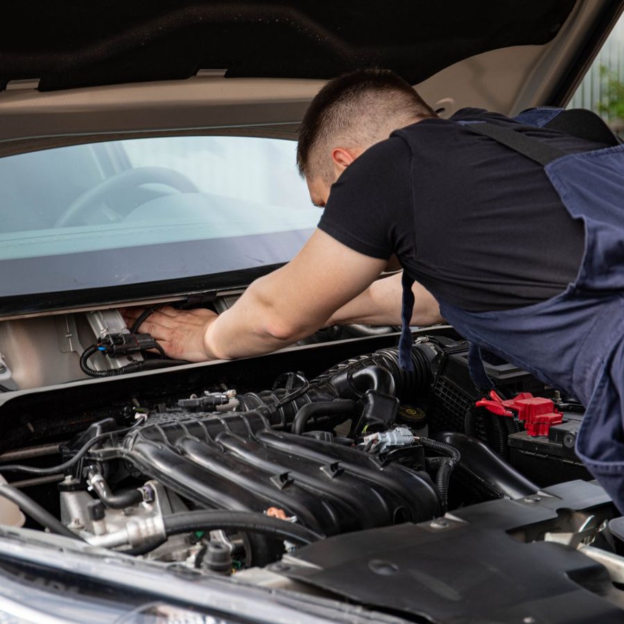 A mechanic working on an engine in a garage.
